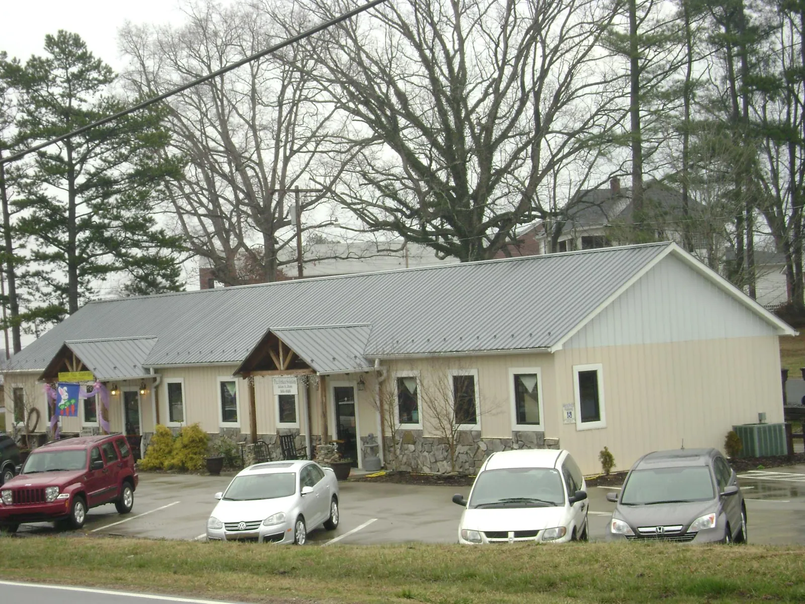 Gray metal roof with timber entry brackets on a small commercial building in Troy